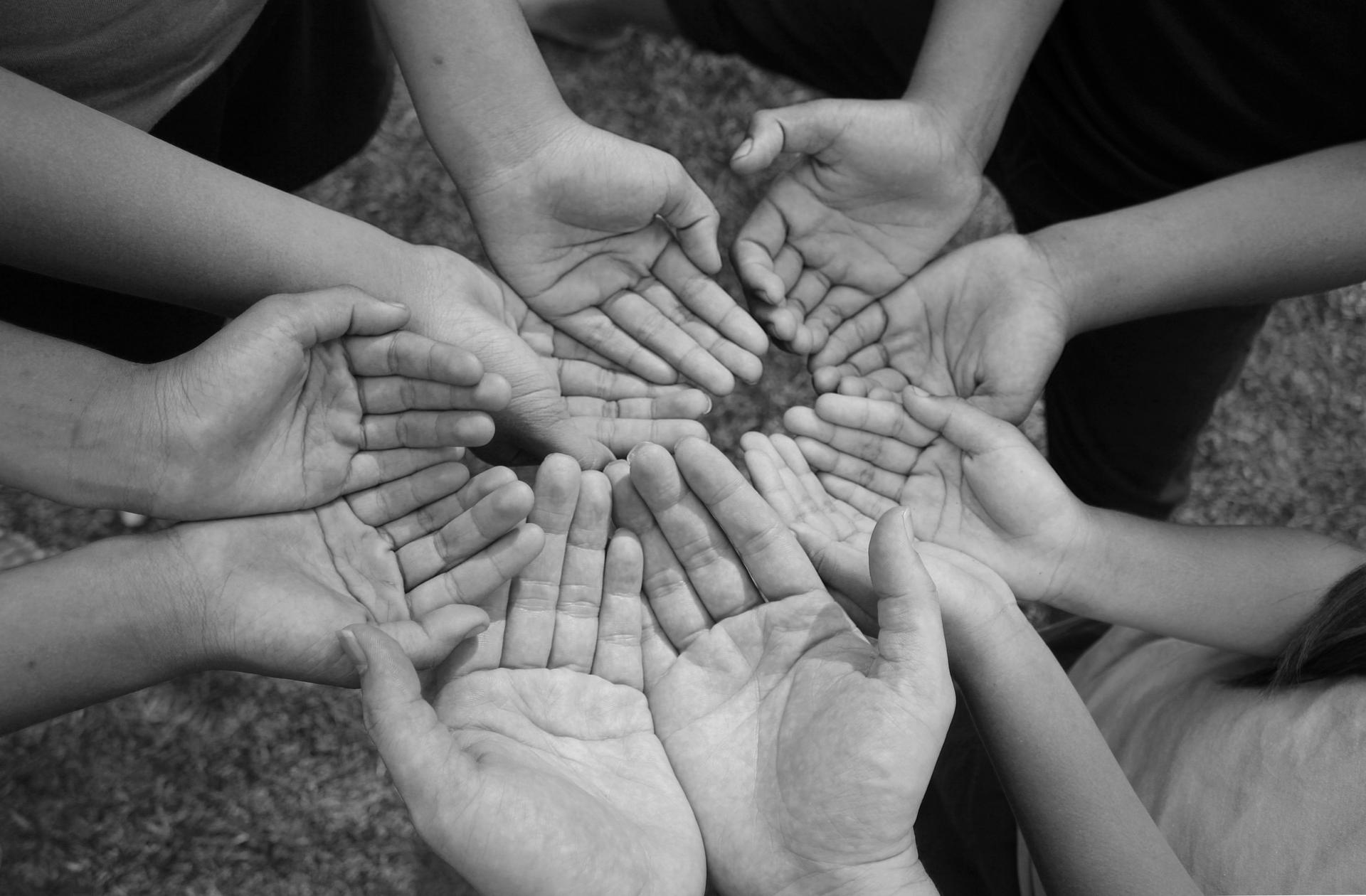 Close up hands of child beggar in vintage dark tone.Open palm hands of group of children begging for help.